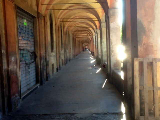 The empty portico walking toward Porta Saragozza on a Sunday morning